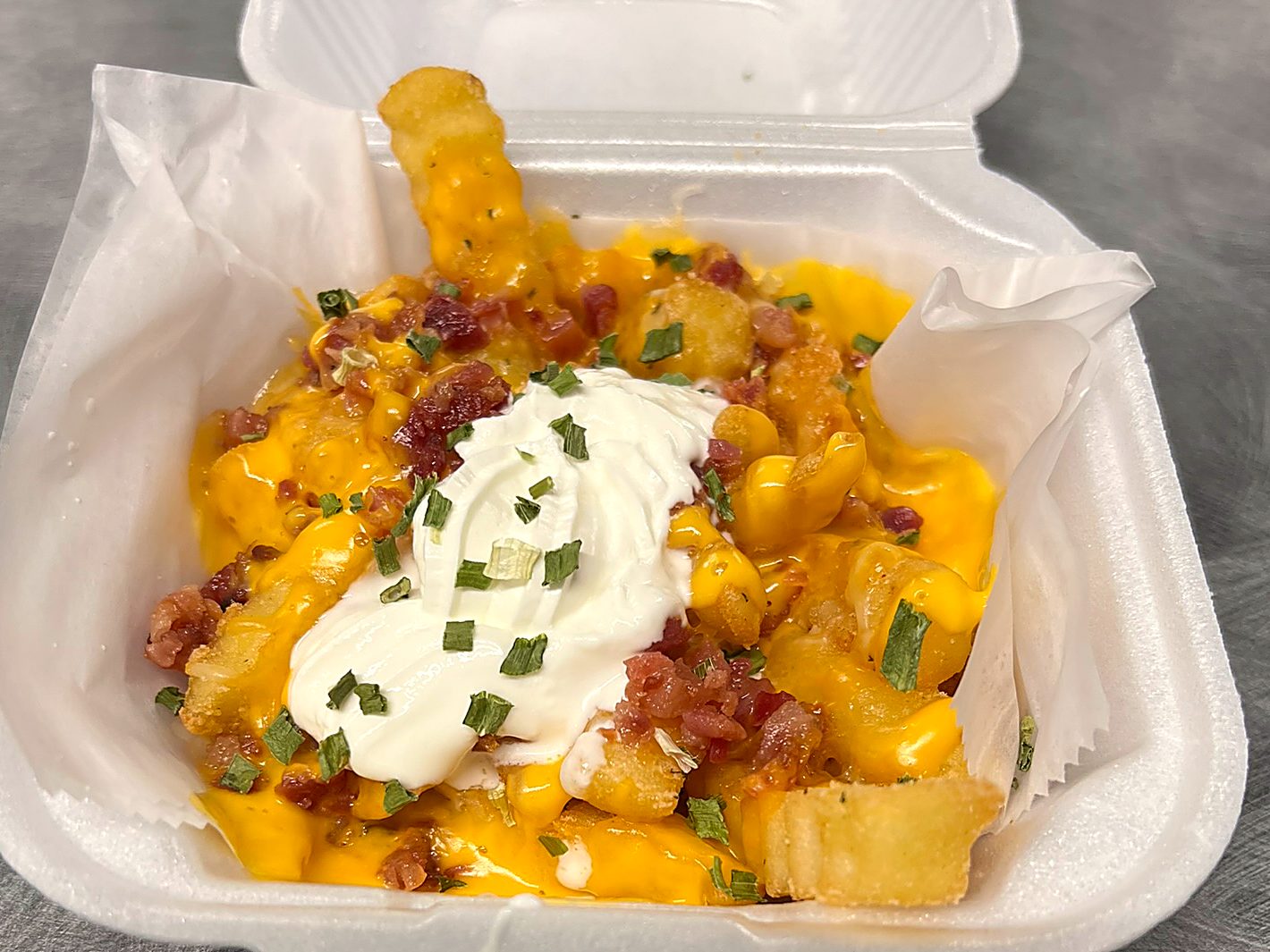 Loaded crinkle fries with cheese, bacon, sour cream and chives