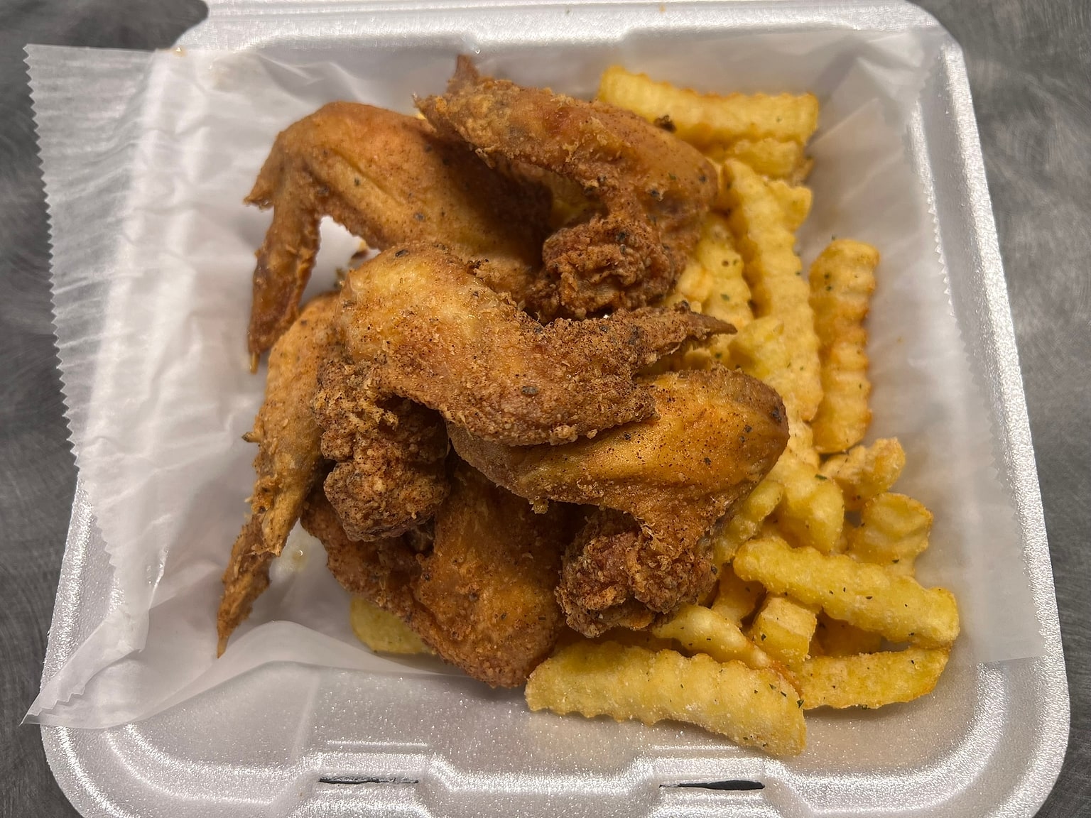 Golden breaded whole wings over seasoned crinkle fries